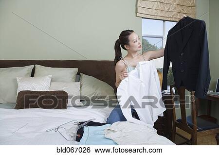 Stock Photograph - Woman packing clothes for business trip. Fotosearch