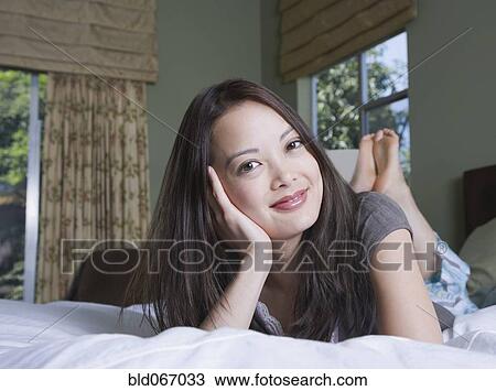 Woman relaxing in bed View Large Photo Image Stock Image - Woman relaxing in bed. Fotosearch
