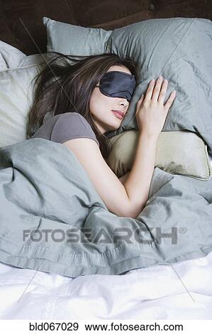 Stock Photo - Woman sleeping with eye mask. Fotosearch