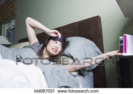 Woman waking to alarm clock View Large Photo Image Stock Image - Woman waking to alarm clock. Fotosearch