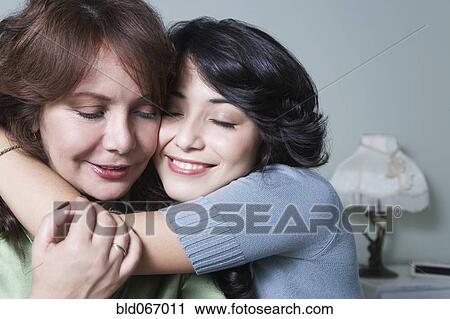 Stock Image - Young woman hugging mother. Fotosearch