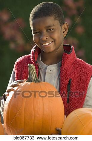 African boy holding pumpkin View Large Photo Image Stock Image - African boy holding pumpkin. Fotosearch