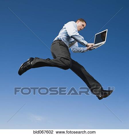 African businessman typing on laptop in mid-air View Large Photo Image Stock Image - African businessman typing on laptop in mid-air. Fotosearch
