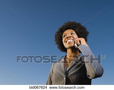 Picture - African businesswoman talking on cell phone. Fotosearch
