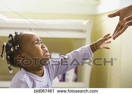 Stock Image - African girl crying and reaching upward. Fotosearch
