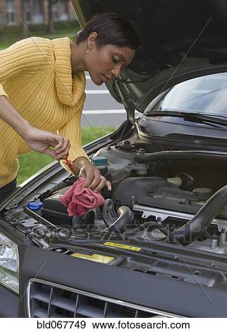 African woman checking oil in car engine View Large Photo Image Stock Photo - African woman checking oil in car engine. Fotosearch
