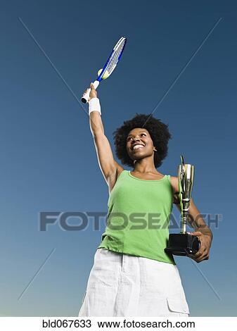 African woman holding tennis racquet and trophy View Large Photo Image Stock Image - African woman holding tennis racquet and trophy. Fotosearch