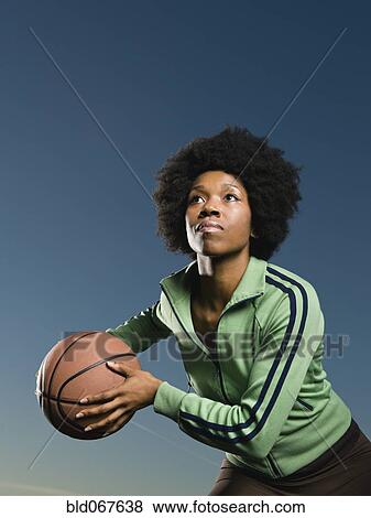 Stock Photo - African woman playing basketball. Fotosearch