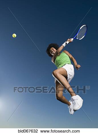 African woman playing tennis in mid-air View Large Photo Image Stock Image - African woman playing tennis in mid-air. Fotosearch