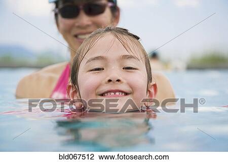 Stock Image - Asian girl and mother in swimming pool. Fotosearch