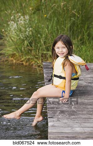 Picture - Asian girl in life jacket on dock. Fotosearch