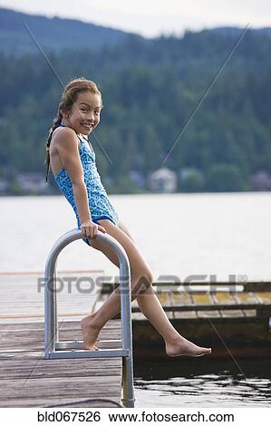 Stock Photograph - Asian girl jumping off dock. Fotosearch