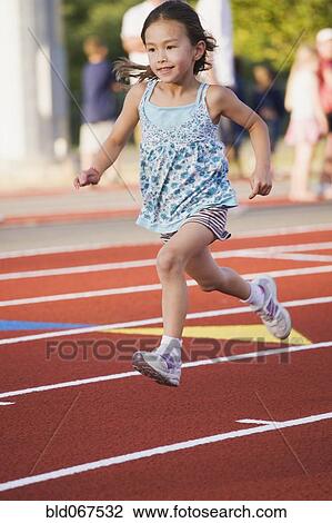 Stock Image - Asian girl running on race track. Fotosearch