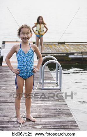 Stock Photography - Asian girls standing on dock. Fotosearch