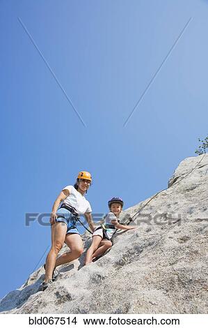 Picture - Asian mother and daughter rock climbing. Fotosearch