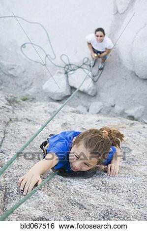 Stock Photograph - Asian mother and daughter rock climbing. Fotosearch