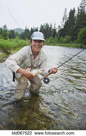 Stock Image - Asian woman fly fishing. Fotosearch