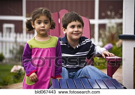 Stock Image - Brother and sister in backyard. Fotosearch