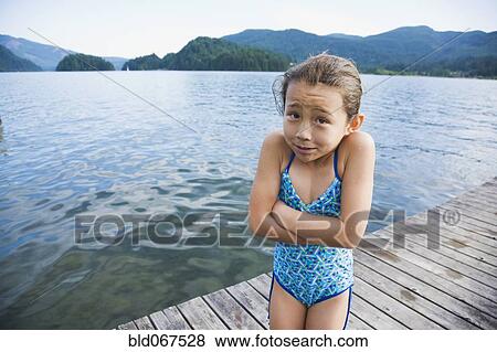 Cold Asian girl standing on dock View Large Photo Image Stock Photo - Cold Asian girl standing on dock. Fotosearch