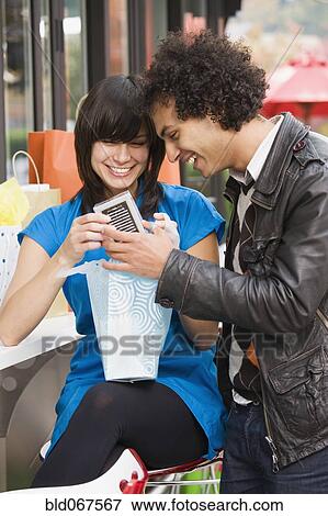 Stock Photo - Couple looking in shopping bag. Fotosearch