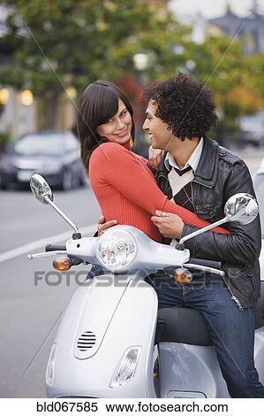 Couple sitting on scooter View Large Photo Image Stock Photography - Couple sitting on scooter. Fotosearch