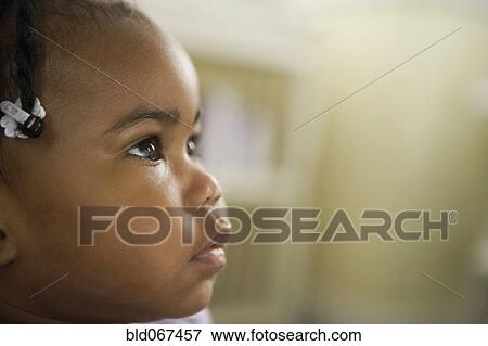 Stock Photo - Curious African girl looking up. Fotosearch