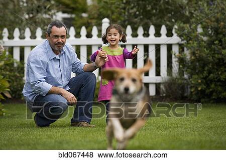 Father and daughter watching dog in backyard View Large Photo Image Stock Photo - Father and daughter watching dog in backyard. Fotosearch