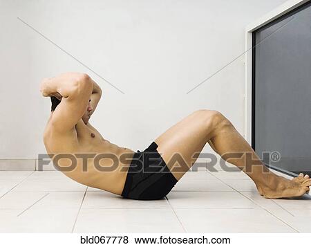 Stock Photo - Hispanic man doing sit ups. Fotosearch