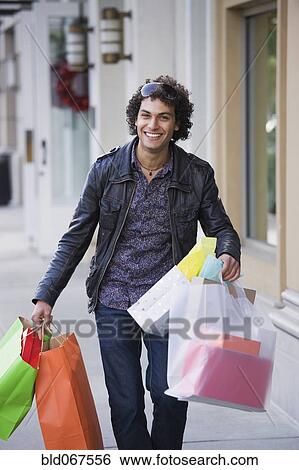 Stock Photograph - Middle Eastern man carrying shopping bags. Fotosearch