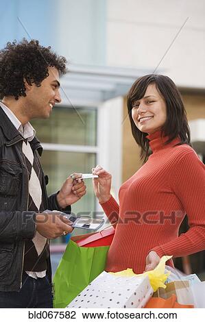 Stock Image - Middle Eastern man giving girlfriend credit card. Fotosearch