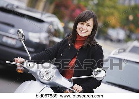 Mixed race woman driving scooter View Large Photo Image Stock Photo - Mixed race woman driving scooter. Fotosearch