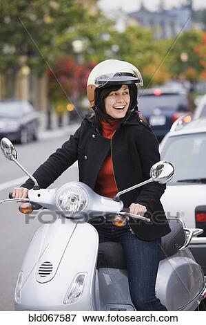 Mixed race woman in helmet driving scooter View Large Photo Image Stock Photo - Mixed race woman in helmet driving scooter. Fotosearch
