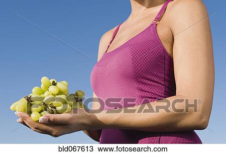 Stock Image - Native American holding a bunch of grapes. Fotosearch