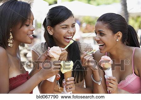 Stock Image - Teenage friends eating ice cream cones. Fotosearch