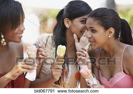 Stock Image - Teenage friends sharing secrets. Fotosearch