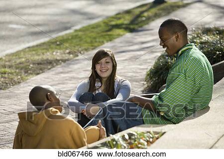 Stock Photograph - Teenage friends talking on steps. Fotosearch