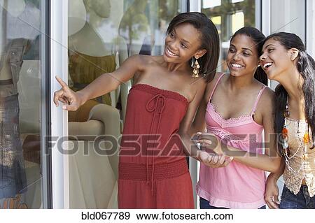 Teenage friends window shopping View Large Photo Image Stock Photo - Teenage friends window shopping. Fotosearch