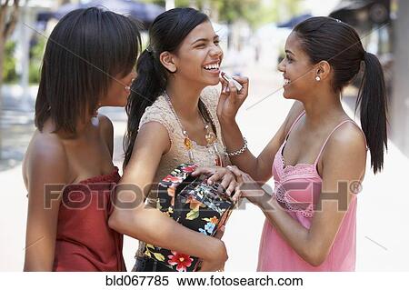 Teenager applying lipstick to friend View Large Photo Image Stock Photography - Teenager applying lipstick to friend. Fotosearch