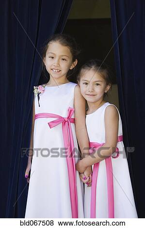 Stock Photo - Young Asian flower girls holding hands. Fotosearch