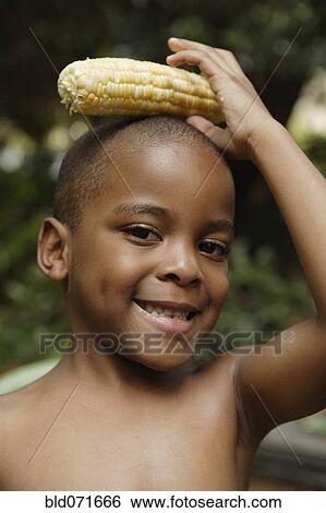 African American boy holding ear of corn on head View Large Photo Image Stock Photograph - African American boy holding ear of corn on head. Fotosearch