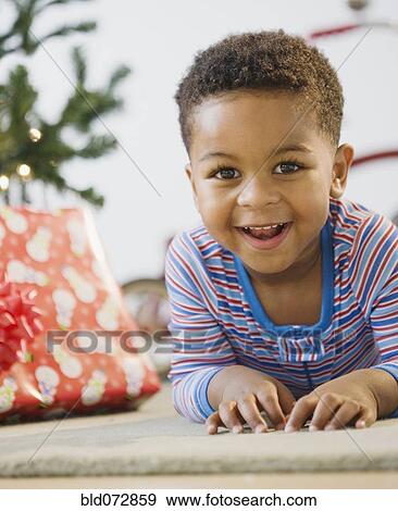 African American boy laying on floor by Christmas tree View Large Photo Image Stock Photo - African American boy laying on floor by Christmas tree. Fotosearch