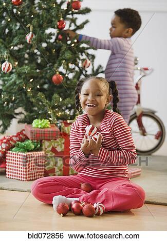 African American girl holding ornaments near Christmas tree View Large Photo Image Stock Photograph - African American girl holding ornaments near Christmas tree. Fotosearch