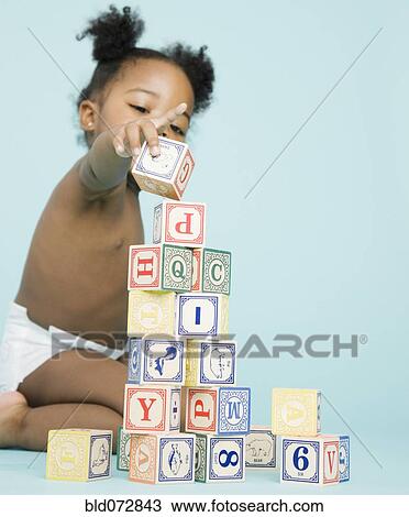 Stock Image - African American girl stacking wooden blocks. Fotosearch