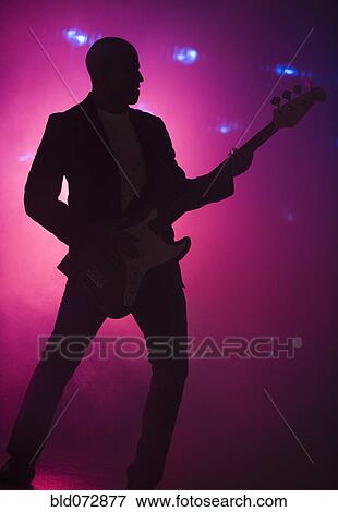 Stock Photo - African American man playing guitar at nightclub. Fotosearch