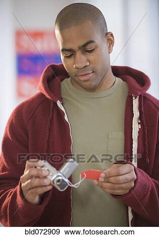 African American man viewing price tag on video camera View Large Photo Image Stock Photo - African American man viewing price tag on video camera. Fotosearch