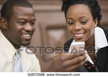 African business people looking at cell phone View Large Photo Image Stock Photo - African business people looking at cell phone. Fotosearch