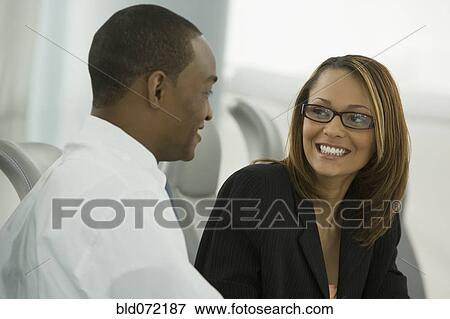 Stock Photo - African business people smiling at each other. Fotosearch