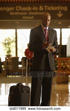 Stock Photo - African businessman dialing cell phone. Fotosearch