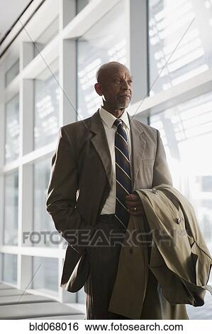 African businessman holding coat View Large Photo Image Stock Photograph - African businessman holding coat. Fotosearch