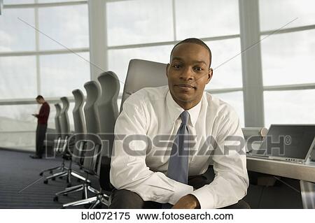 Stock Photography - African businessman posing in conference room. Fotosearch